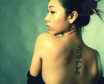 Lady with baybayin tattooed vertically on her back. Baybayin is typically written horizontally from left to right. 